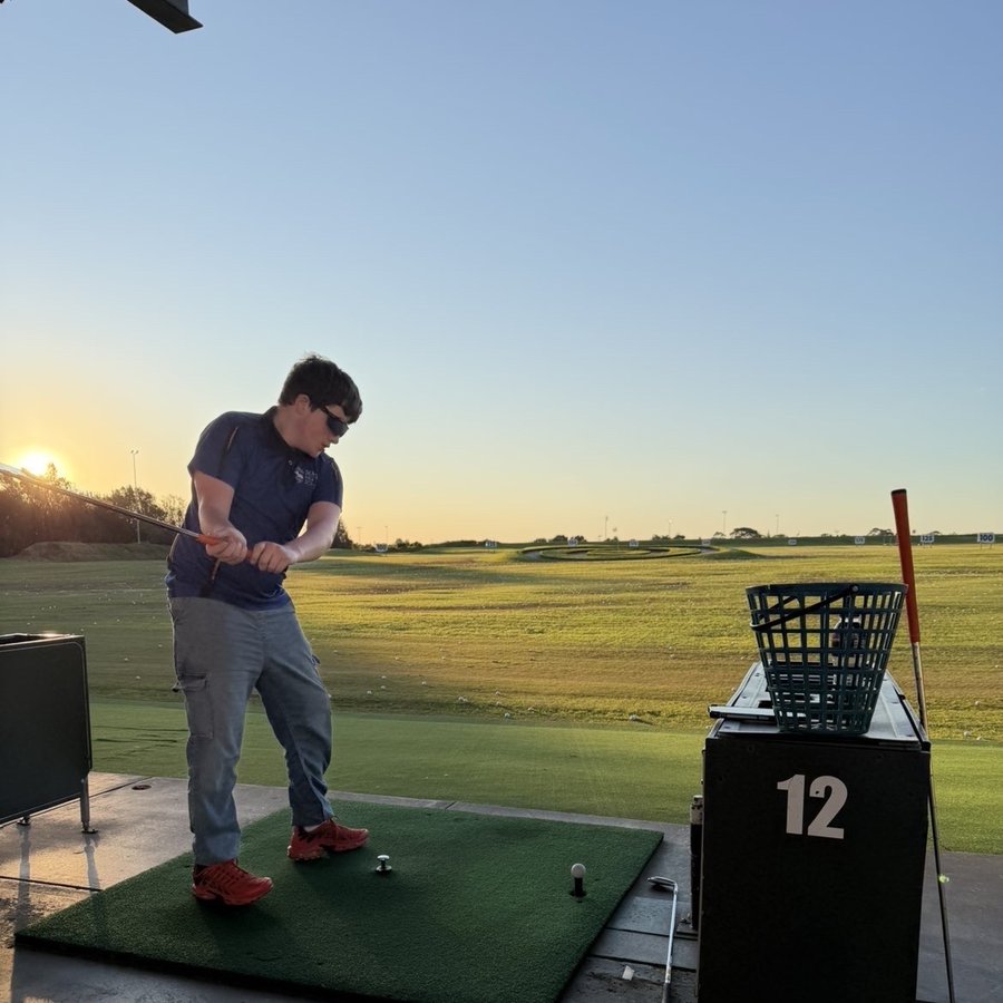 Participant practising golf at the driving range