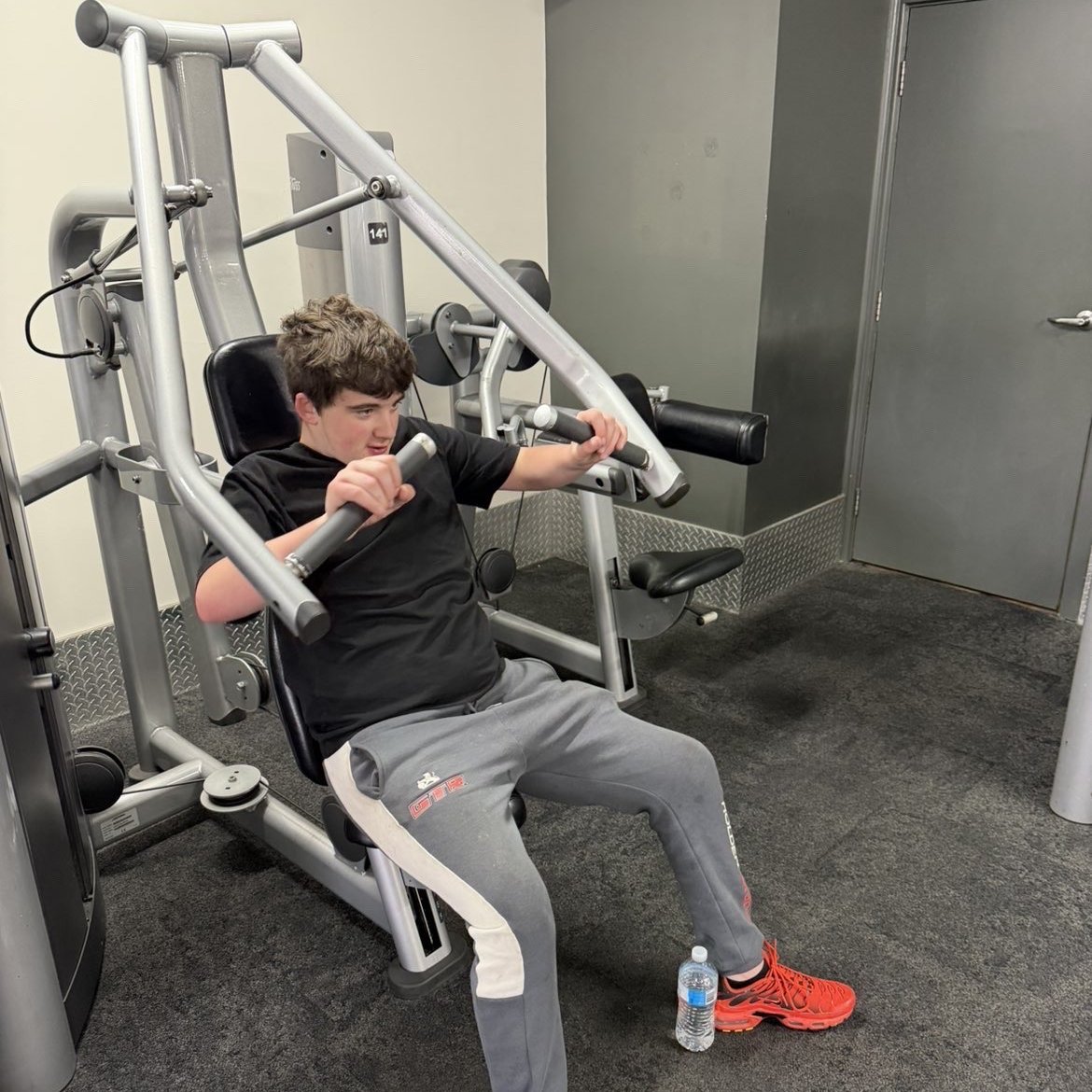 Participant building strength during a one-on-one gym session